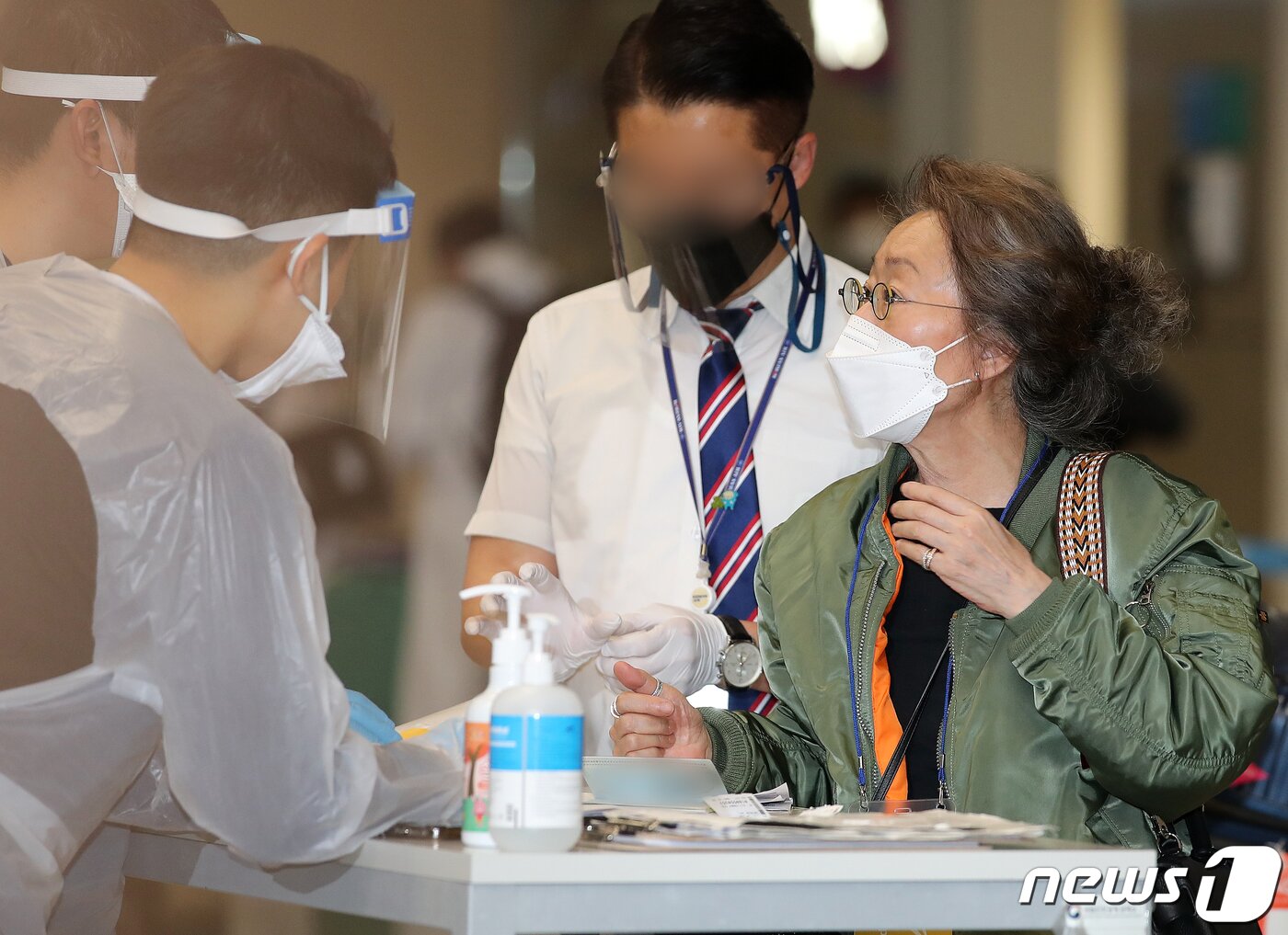 본문 이미지 - 입국 후  인천공항 육군 검역 지원단에게 입국 안내를 받고 있는 윤여정. 2021.5.8/뉴스1 ⓒ News1 김진환 기자