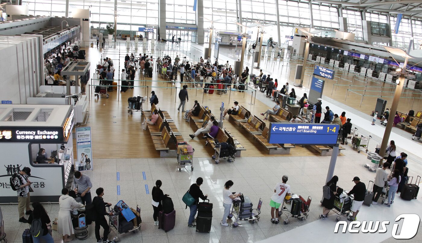 본문 이미지 - 여행객들이 11일 오후 인천국제공항 제1터미널에서 출국하기 위해 줄을 서 있다. 정부는 코로나19 백신 접종 완료자에 한해 이르면 7월부터 싱가포르와 괌, 사이판 등 단체 해외여행을 허용하는 여행안전권역(트래블 버블)을 추진한다고 밝혔다. 권현진 기자