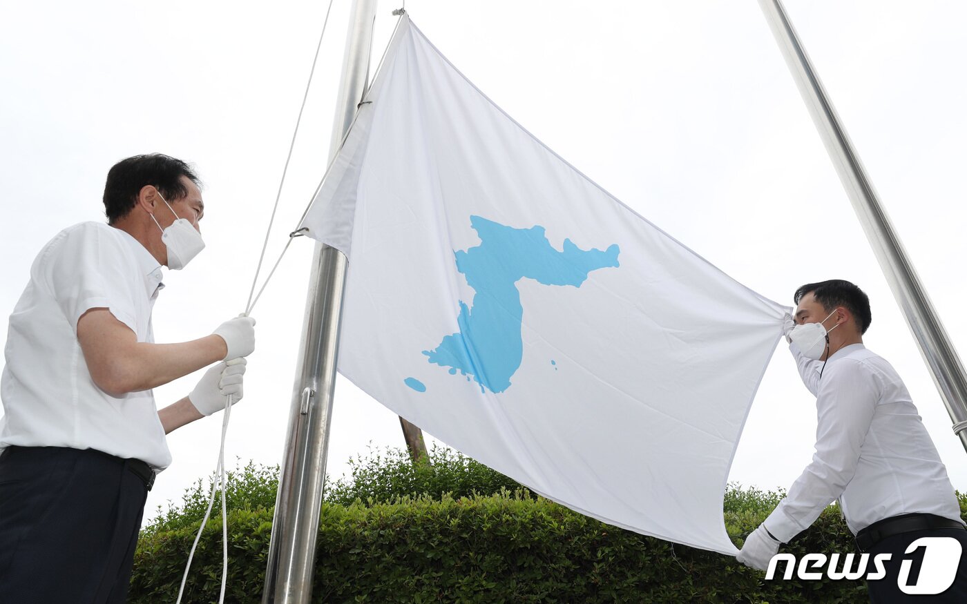 본문 이미지 - 6·15남북공동선언 21주년인 15일 경기도 수원시 팔달구 경기도의회에서 직원들이 한반도기를 게양하고 있다. 김영운 기자