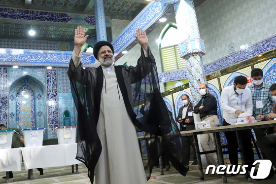 테헤란 시내의 한 투표소에서 18일 세예드 에브라힘 라이시 후보가 한 표를 행사한 뒤 손을 흔들어 보이고 있다. © 로이터=뉴스1