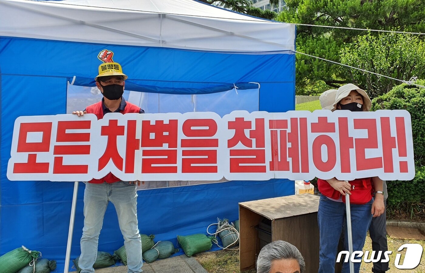 본문 이미지 - 2021 부산 차별철폐대행진 참가자들이 2일 대행진 선포식에서 '모든 차별을 철폐하라' 문구의 피켓을 들고 있다.2021.6.2/ⓒ 뉴스1 노경민 기자