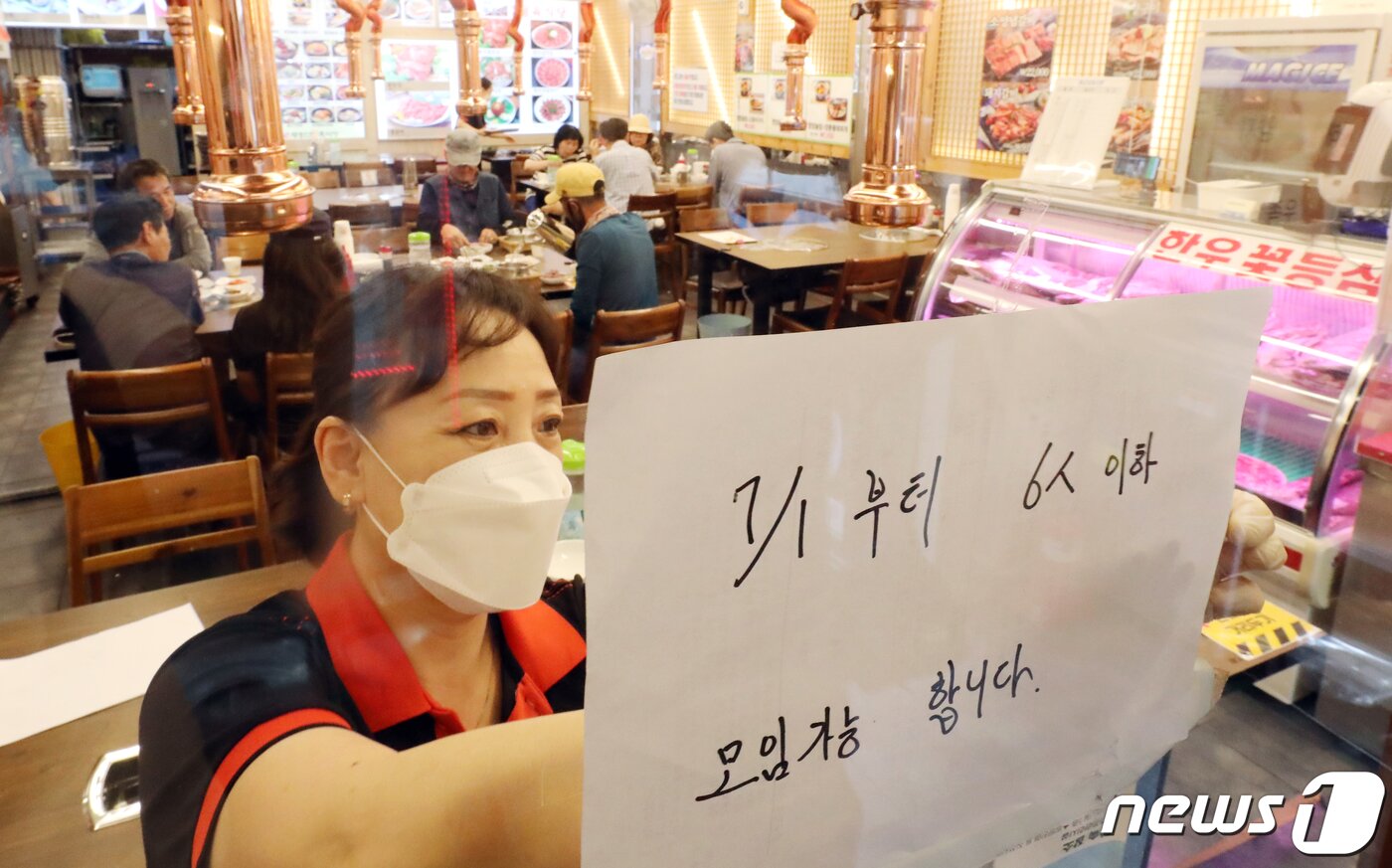 본문 이미지 - 21일 서울 명동 한 식당에서 종업원이 '7월 1일 부터 6인 인하 모임 가능' 안내문을 붙이고 있다. 정부의 사회적 거리두기 지침 완화로 수도권에서는 거리두기 완화를 단계적으로 적용키로 해 내달 1일부터 14일까지 6인까지 모임을 허용하고, 15일 이후에는 8인 모임까지 허용하게 된다. 1 김명섭 기자