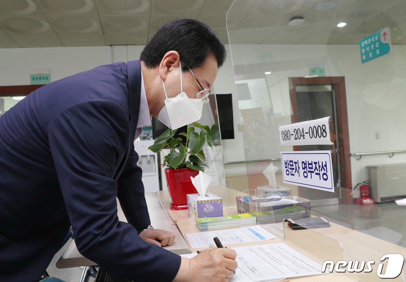 본문 이미지 - 김영록 전라남도지사가 23일 오전 무안군 무안읍 무안보건소에서 코로나19 백신 2차 접종에 앞서 방문자 명부작성을 하고 있다. 지난 4월 9일 1차 접종을 한 지 75일 만이다.(전남도 제공) 2021.6.23/뉴스1 ⓒ News1 전원 기자