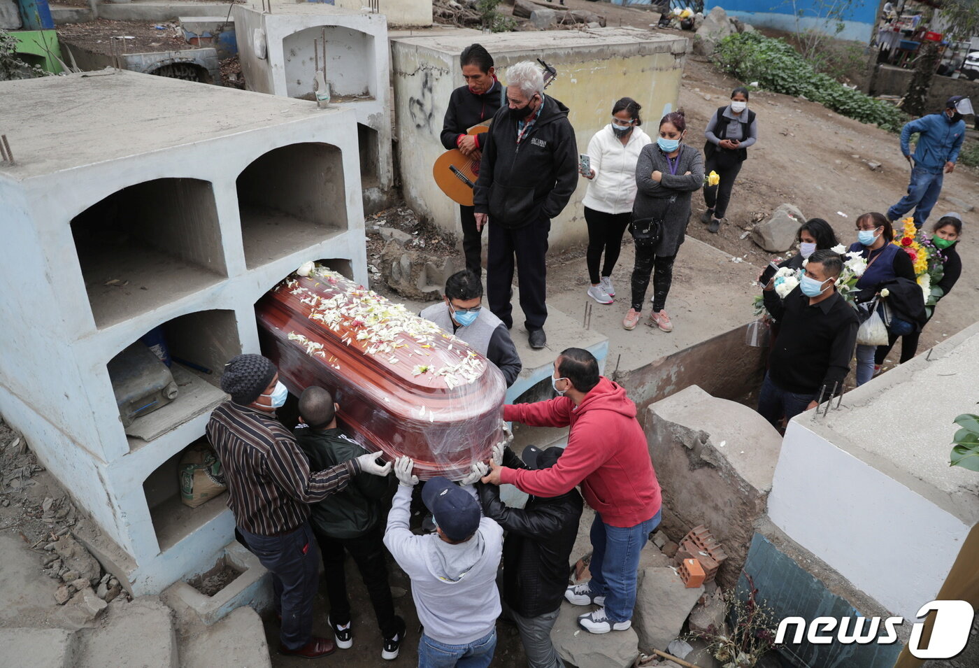 본문 이미지 - 페루 리마 한 공동묘지에서 2021년 6월 1일 코로나19 사망자의 가족들이 고인의 관을 안치하고 있다. 페루는 현재 기준 전 세계에서 인구 당 코로나19 관련 사망률이 가장 높다. ⓒ 로이터=뉴스1 ⓒ News1 최서윤 기자