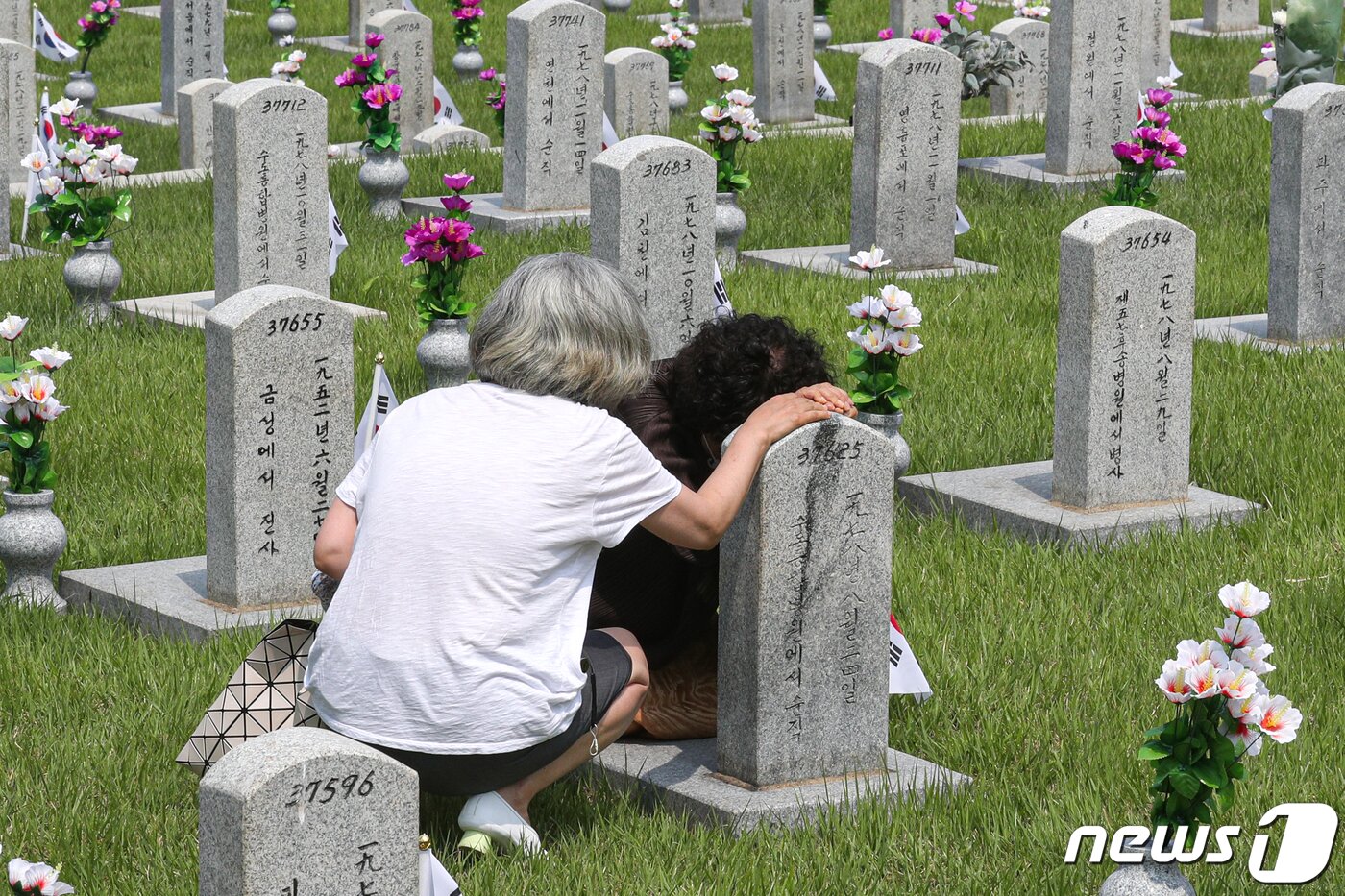본문 이미지 - 6.25전쟁 제71주년을 이틀 앞둔 23일 오후 서울 동작구 국립서울현충원에서 한 유가족이 가족의 묘비에서 눈물을 훔치고 있다. 성동훈 기자