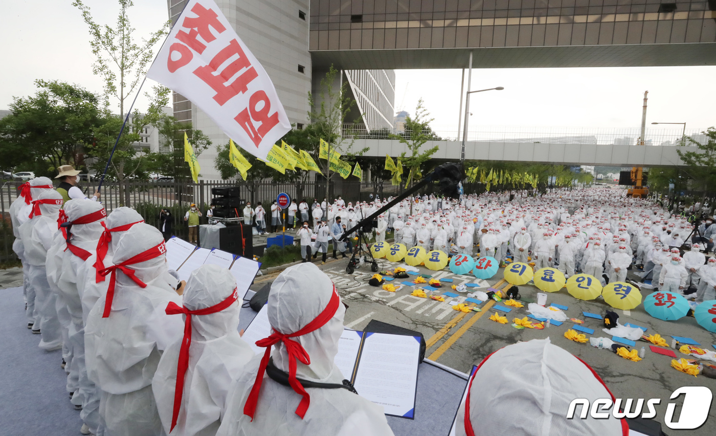 (세종=뉴스1) 장수영 기자 = 보건의료노조 조합원들이 23일 세종시 정부세종청사 보건복지부 앞에서 열린 '산별총파업 선포 결의대회'에서 방호복을 입고 결의문을 낭독하고 있다.노조 …