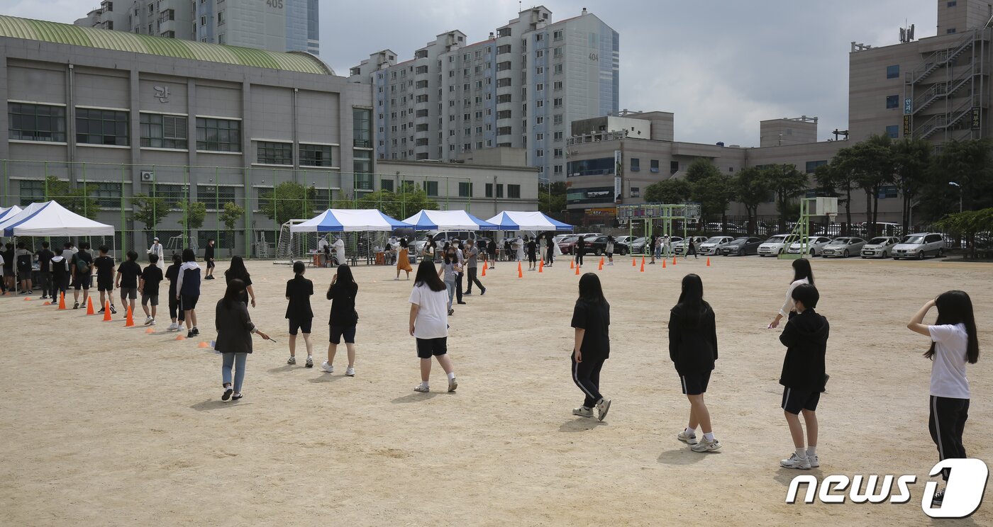 본문 이미지 - 24일 오전 울산 중구 한 중학교 운동장에 마련된 임시 선별진료소에서 학생과 교직원 등 700여명을 대상으로 코로나19 전수검사가 이뤄지고 있다. 이날 이 학교 교사 1명과 학생 7명이 코로나19 확진 판정을 받아 방역에 비상이 걸렸다. 울산지역 전체 학교는 오는 28일부터 전면 등교를 앞두고 있다. 2021.6.24/뉴스1 ⓒ News1 윤일지 기자