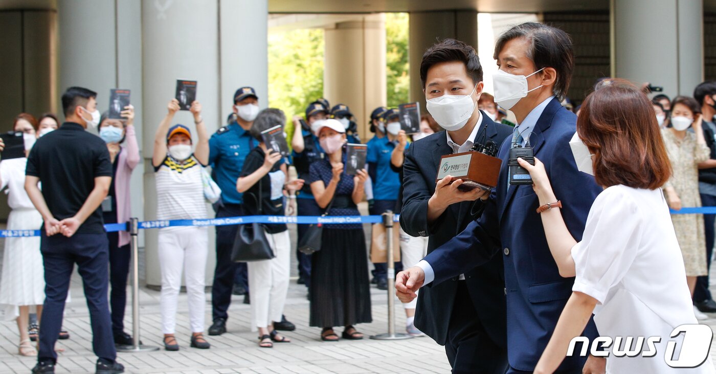 본문 이미지 - 조국 전 법무부 장관이 25일 서울 서초구 중앙지방법원에서 열린 공판에 출석하자 지지자들이 조 전 장관이 쓴 회고록 '조국의 시간'을 든채 응원하고 있다.  2021.6.25/뉴스1 ⓒ News1 안은나 기자