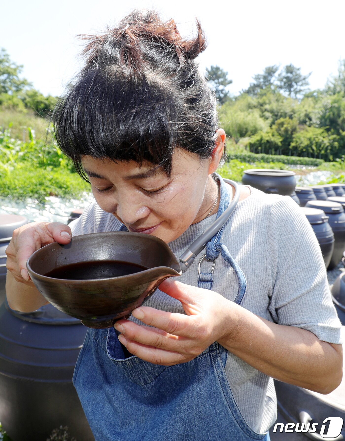 본문 이미지 - 전북 김제시 진봉면에 자리한 &#39;지애의 봄향기&#39; 함지애 대표가 장독대에 담겨진 천연발효식초를 살펴보고 있다. 2021.6.25/뉴스1 ⓒ News1 유경석 기자