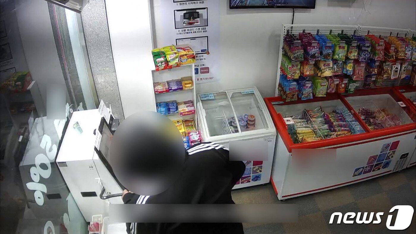 본문 이미지 - 특수절도 혐의로 구속된 30대 A씨가 파주시의 한 24시간 아이스크림 무인점포에서 현금계산기를 도구를 이용해 열고 있다. (파주경찰서 제공) ⓒ 뉴스1