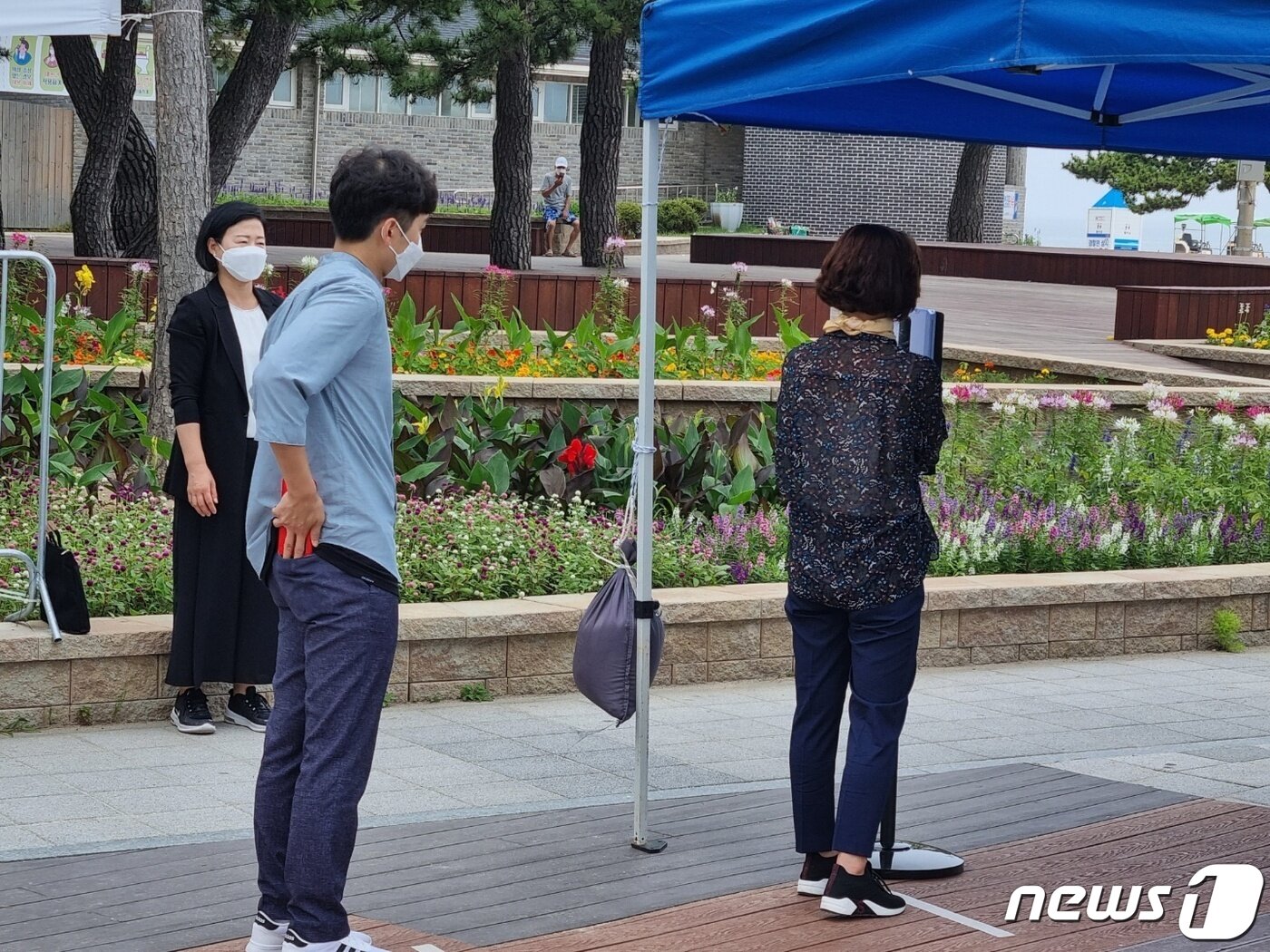 본문 이미지 - 코로나19 4차 대유행이 본격화 되고 있는 가운데 14일 강원 강릉시가 개장을 앞둔 경포해수욕장에서 진행한 방역 시연회에서 입장객들이 발열체크를 위해 대기하고 있다.2021.7.14/뉴스1 ⓒ 윤왕근 기자