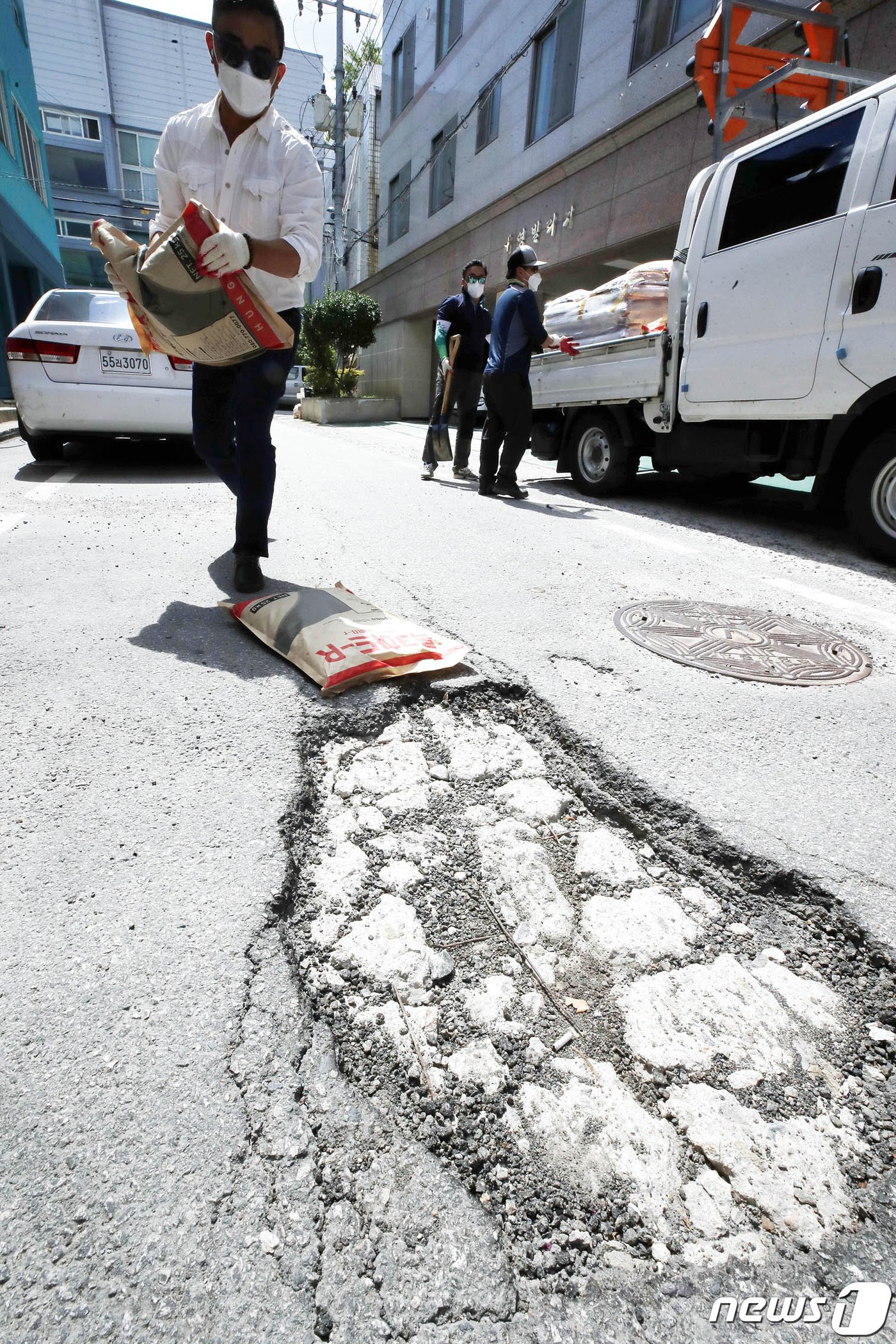 본문 이미지 - 15일 광주 북구 주택가 이면도로에서 북구 건설과 도로관리팀 직원들이 지난 집중호우로 생긴 포트홀 복구 작업을 하고 있다.(광주북구 제공)2021.7.15/뉴스1 ⓒ News1 허단비 기자