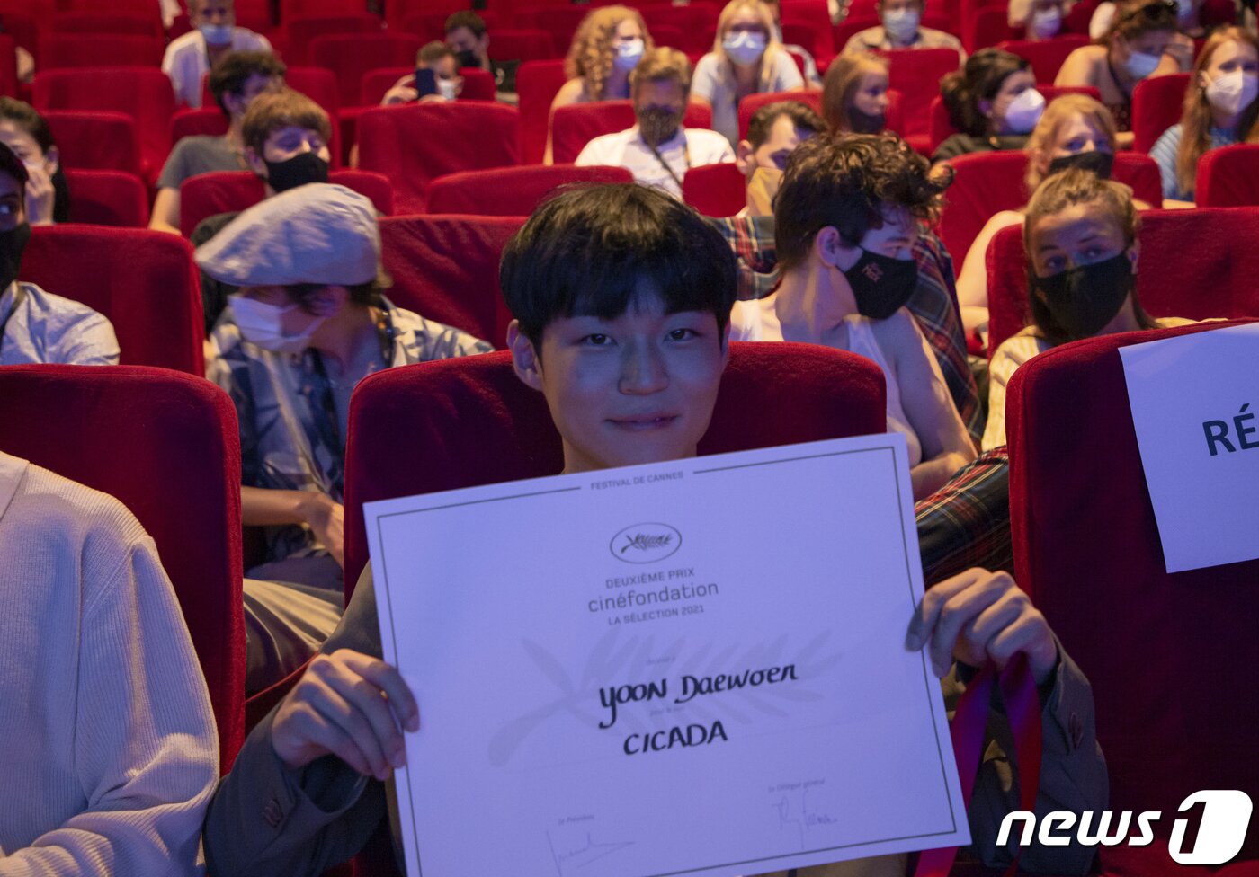 본문 이미지 - 15일(현지시간) 칸 국제영화제가 열리고 있는 프랑스 남부 휴양도시 칸, 팔레 데 페스티발 뷔뉘엘관에서 시네파운데이션 경쟁부문에 오른 ‘매미’의 윤대원 감독이 2등 상을 수여받은 뒤 자리에 돌아와 상장을 펴보이고 있다. 심사위원단은 ‘매미’의 윤대원 감독은 빛나는 연출로 인상적인 생명력을 보여줘 2등 상을 수여한다고 밝혔다. 칸 국제영화제 시네파운데이션 경쟁부문 3등은 카리나 가브리엘라 다소보누 감독(루마니아)의 ‘PRIN ORAS CIRCULA SCURTE POVESTI DE DRAGOSTE’와 로드리고 리베이로 감독(브라질)의 ‘CANTAREIRA’가, 1위는 테오 드정 감독(벨기에)의 도룡뇽아이(L’ENFANT SALAMANDRE)가 수상했다. 2021.7.16/뉴스1 ⓒ News1 이준성 프리랜서기자