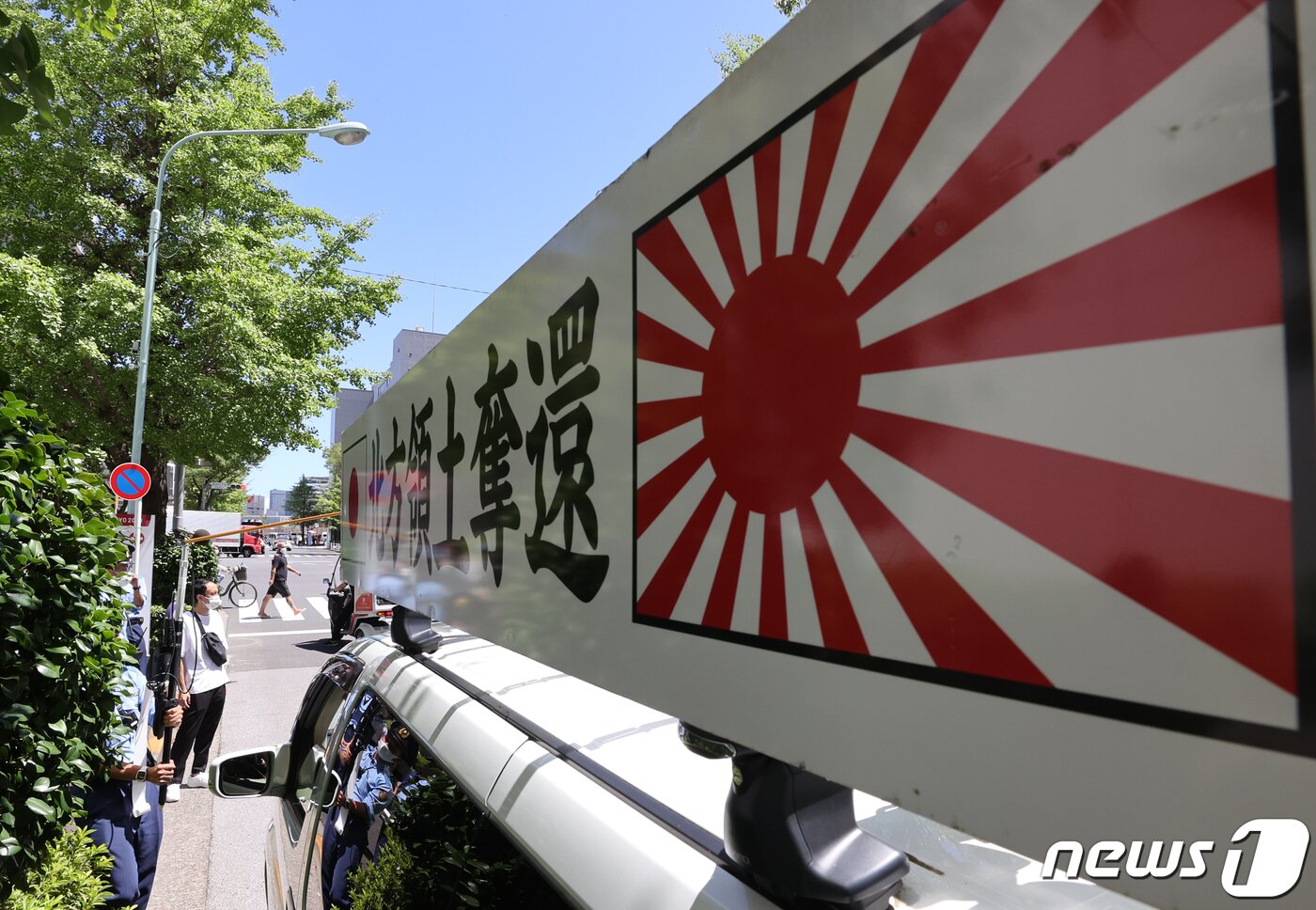 본문 이미지 - 18일 도쿄 올림픽 선수촌 앞에서 욱일기가 프린트 된 일본 우익단체 차량이 정차돼 있다.우익단체는 확성기를 통해 한국을 비난하는 발언을 지속했다. . 2021.7.18/뉴스1 ⓒ News1 송원영 기자