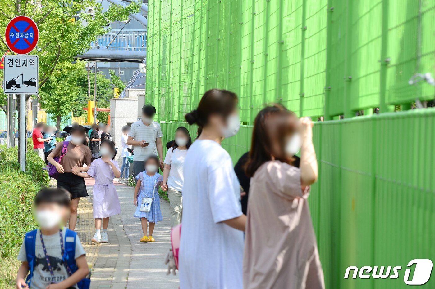 본문 이미지 - 19일 오후 광주 한 초등학교 재학생이 코로나19에 확진된 가운데 학부모들이 담장 너머 검체 채취 과정을 지켜보고 있다. 광주시에 따르면 확진된 프리랜서 요리강사가 방과후수업을 위해 해당학교를 방문했고, 이 과정에서 재학생 1명이 확진판정을 받았다. 2021.7.19/뉴스1 ⓒ News1 정다움 기자