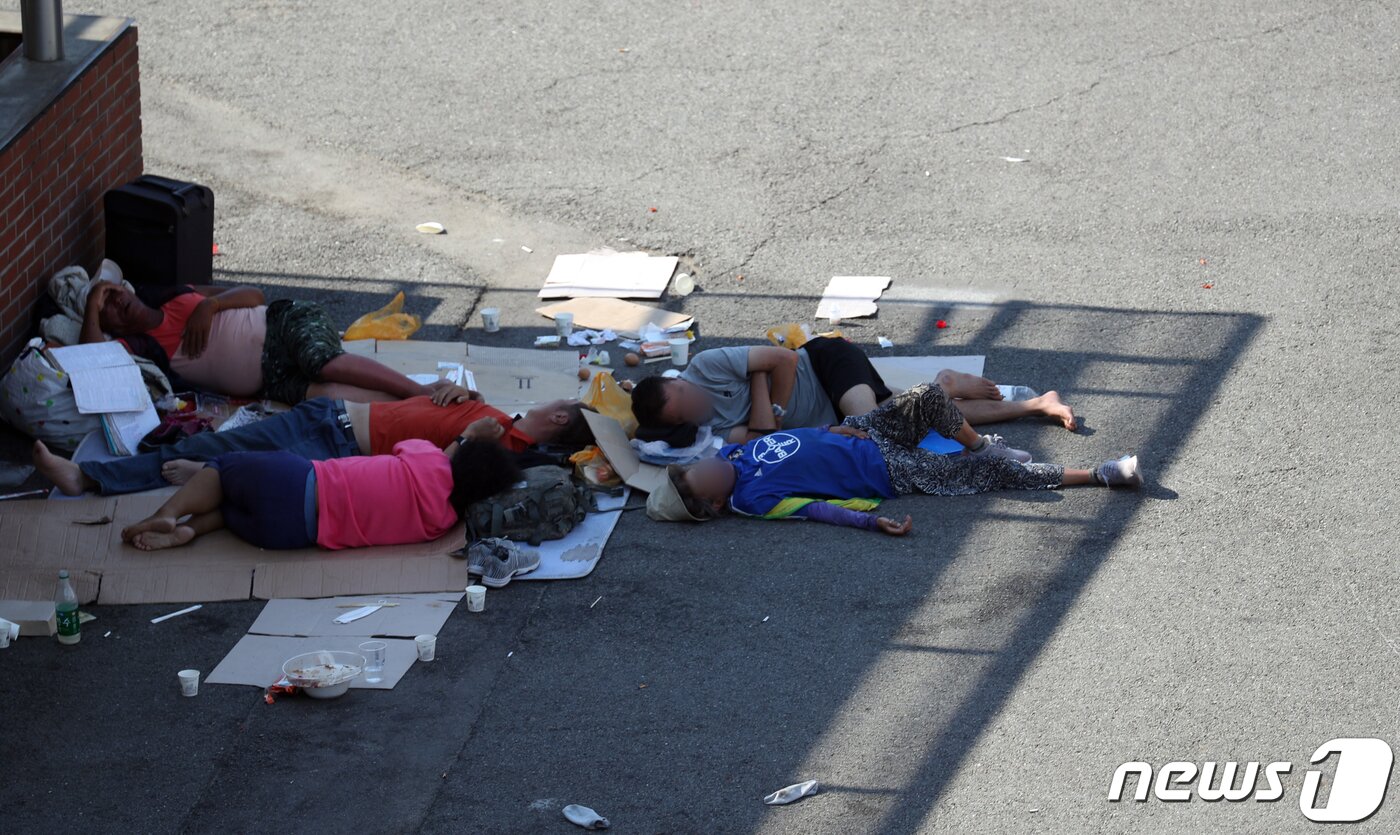 본문 이미지 - 낮기온 35도에 이르는 폭염이 연일 계속되고 있는 가운데 노숙자들이22일 서울 중구 서울역 광장 그늘진 곳에서 잠을 자고 있다. 2021.7.22/뉴스1 ⓒ News1 김명섭 기자