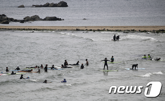 울산지역에 닷새째 폭염주의보가 이어지고 있는 23일 울산 울주군 진하해수욕장에서 동호인들이 서핑을 즐기고 있다. 2021.7.23/뉴스1 © News1 