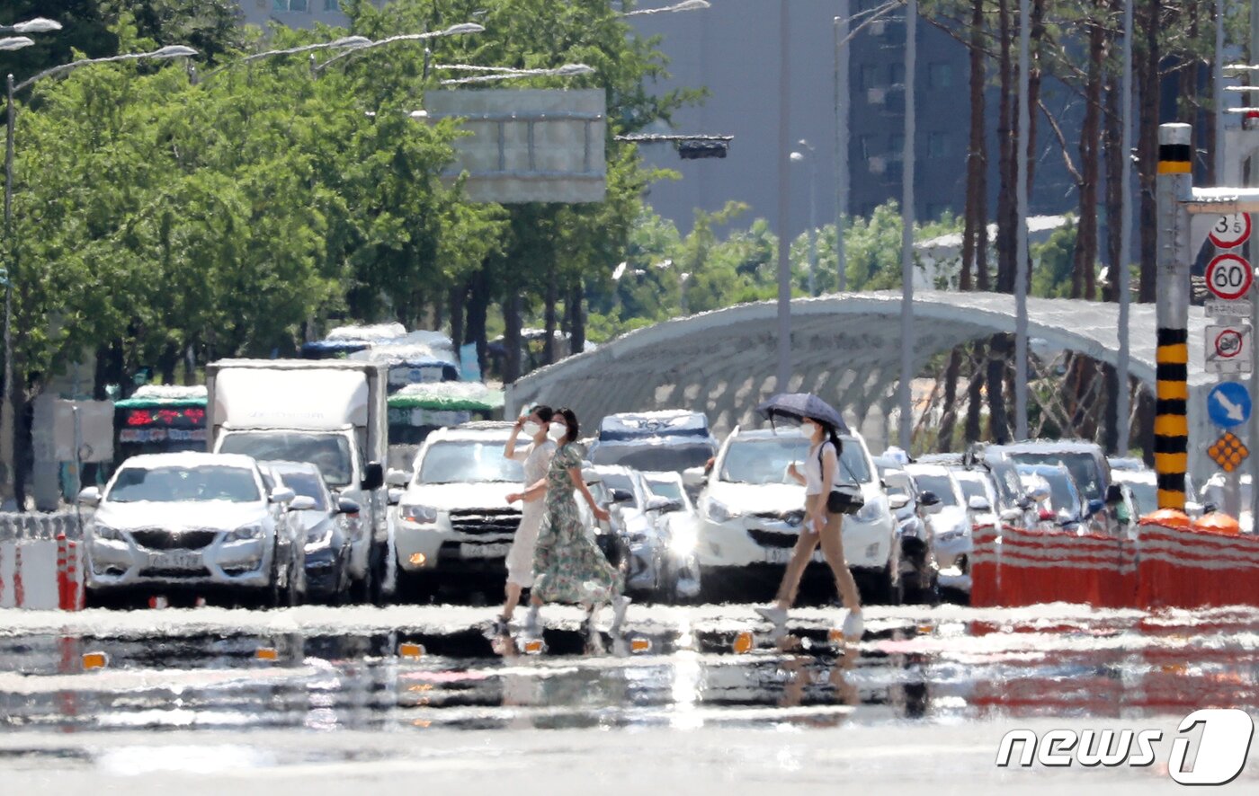 본문 이미지 - 서울에 폭염경보가 발령되고 전국에 가마솥 더위가 이어지는 지난 25일 오후 서울 여의도공원 앞 횡단보도에 아지랑이가 피어오르고 있다. 행안부는 폭염 심화에 따라 온열질환 예방을 위해 외출을 자제하고 물 마시기와 실외 활동시 폭염 안전수칙 준수 등을 당부했다. 2021.7.25/뉴스1 ⓒ News1 박세연 기자