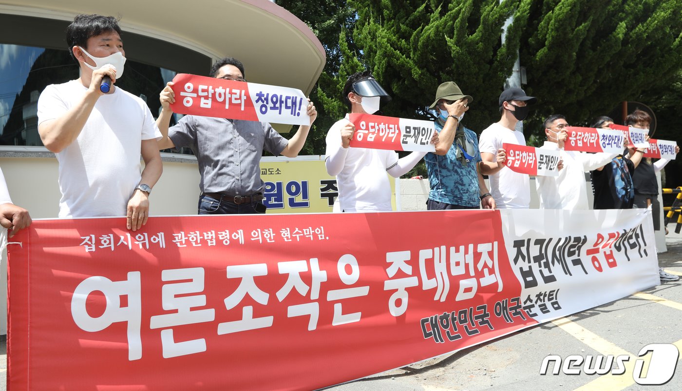 김경수 전 경남도지사 반대 단체가 26일 오전 경남 창원시 마산구 창원교도소 앞에서 여론조작 관련 현수막을 들고 있다. 2021.7.26/뉴스1 ⓒ News1 여주연 기자