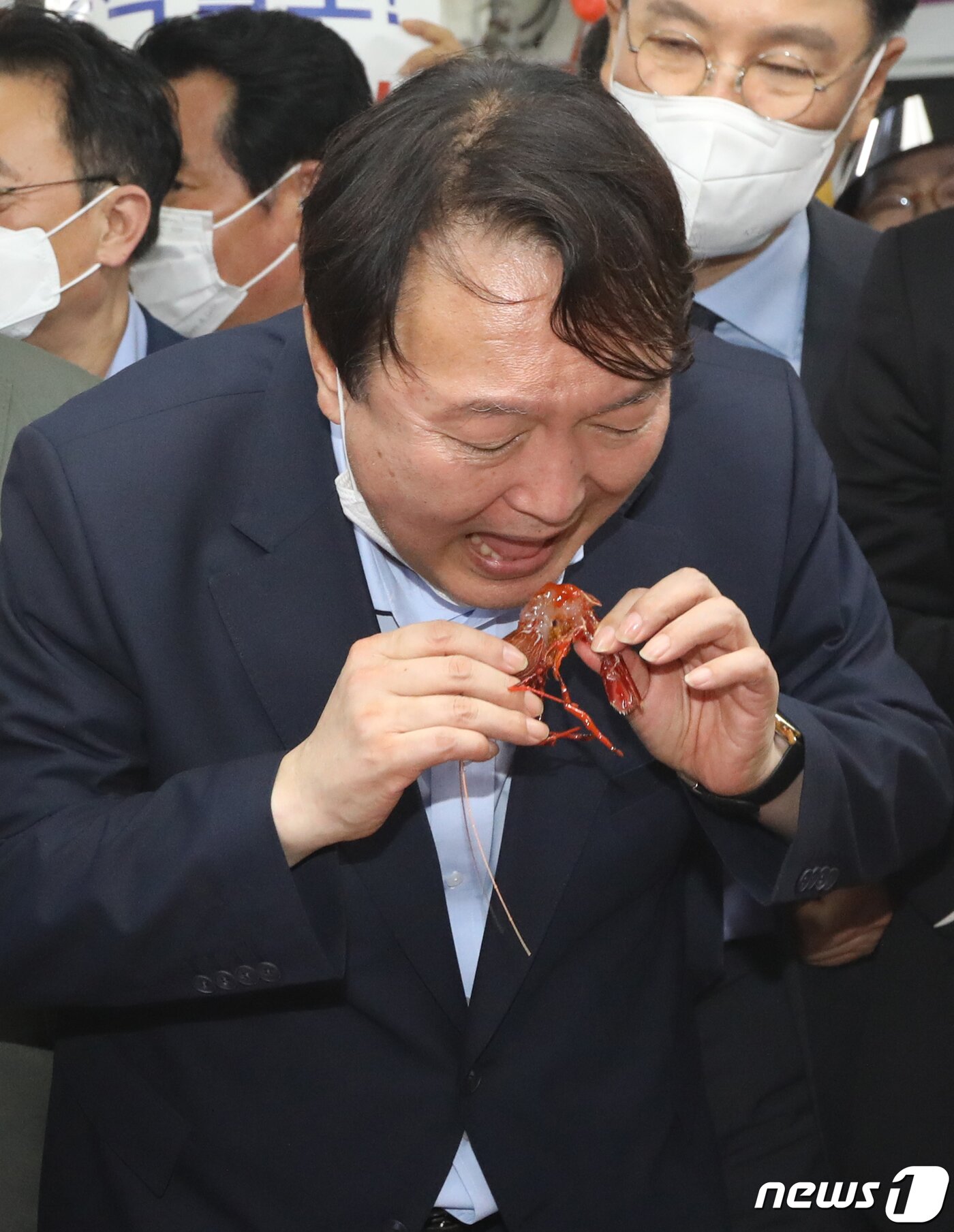 본문 이미지 - 윤석열 전 검찰총장이 27일 오후 부산 중구 자갈치시장을 찾아 상인이 건넨 새우를 맛보고 있다. 2021.7.27/뉴스1 ⓒ News1 여주연 기자