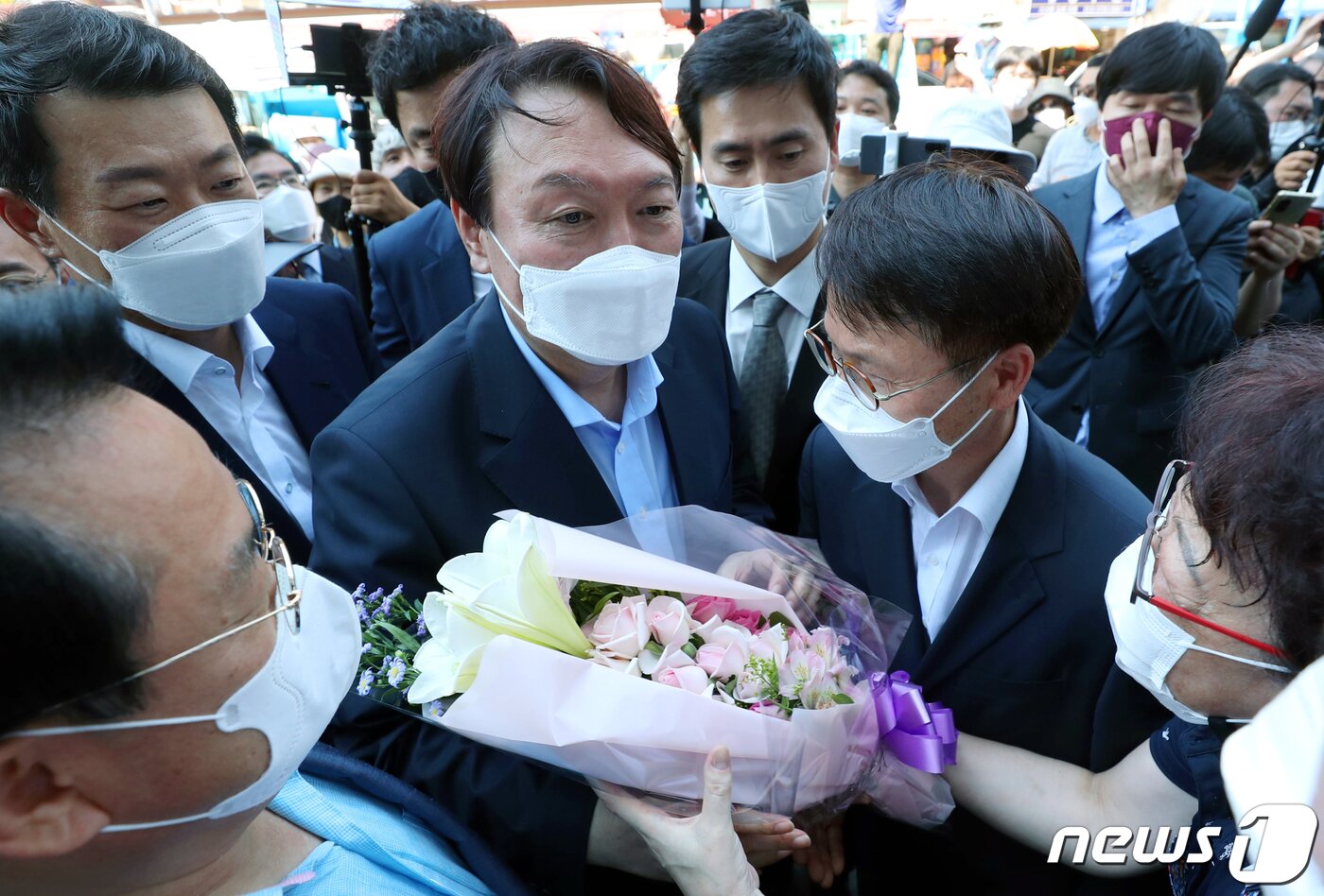 본문 이미지 - 윤석열 전 검찰총장이 27일 오후 부산 중구 자갈치시장에서 지지자에게 꽃다발을 받고 있다. 2021.7.27/뉴스1 ⓒ News1 부산사진공동취재단