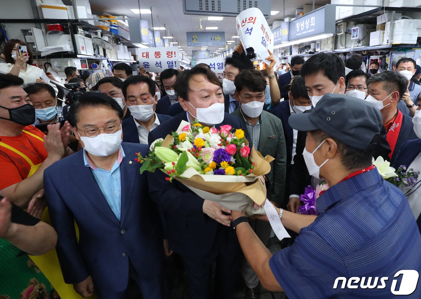 본문 이미지 - 윤석열 전 검찰총장이 27일 오후 부산 중구 자갈치시장에서 상인이 건넨 꽃다발을 받고 있다. 2021.7.27/뉴스1 ⓒ News1 부산사진공동취재단
