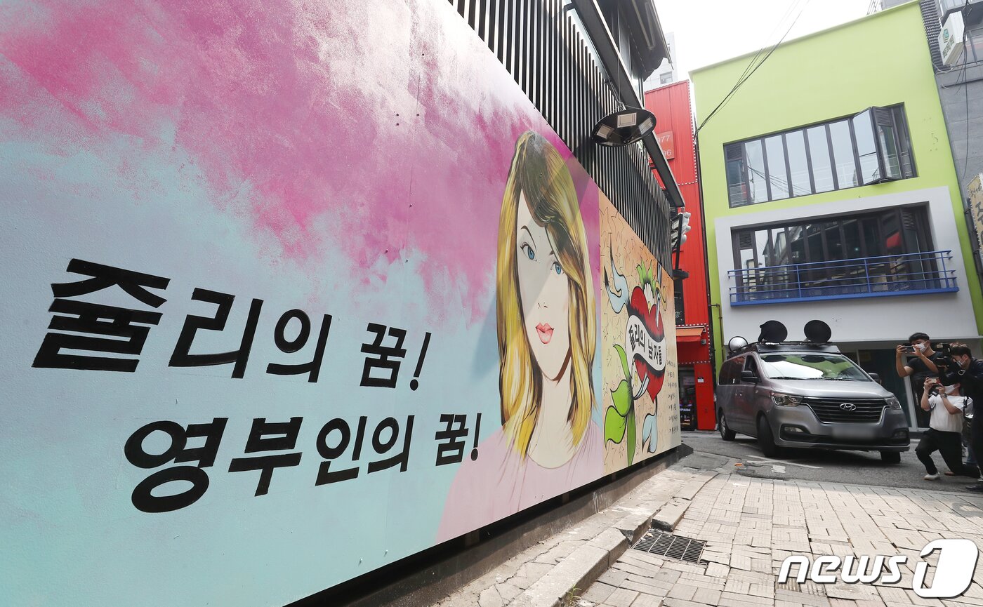 본문 이미지 - 29일 서울 종로구의 한 서점 벽면에 윤석열 전 검찰총장의 배우자 김건희 씨를 비방하는 내용의 벽화가 그려져 있다. 앞서 지난달 김건희씨는 자신이 '강남 유흥주점의 접객원 쥴리였다'는 루머에 대해 "누가 소설을 쓴 것＂이라고 해명했다. 윤석열 대선 예비후보 캠프는 지난 27일 김건희에 대한 루머가 확산되고 있는 것에 강력히 대응하겠다고 밝혔다. 2021.7.29/뉴스1 ⓒ News1 민경석 기자