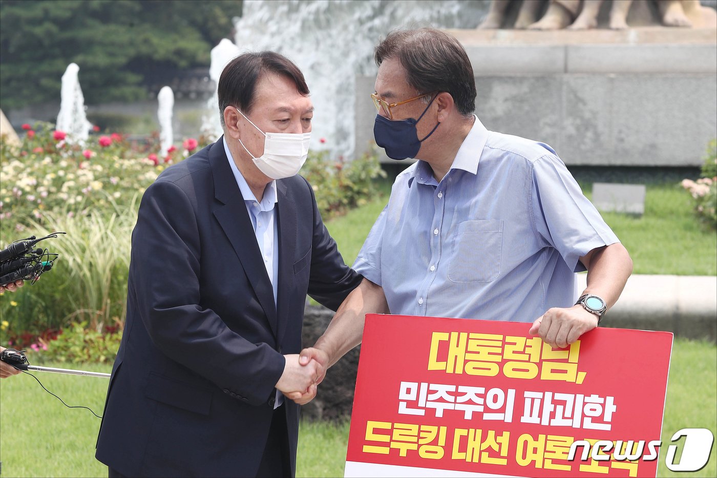 윤석열  대통령이 서울 종로구 청와대 앞 분수대 광장에서 드루킹 댓글 조작 사건과 관련해 문재인 대통령의 사과를 촉구하며 1인 시위를 하고 있는 정진석 국민의힘 의원을 격려하고 있다. 2021.7.29/뉴스1 ⓒ News1 국회사진취재단