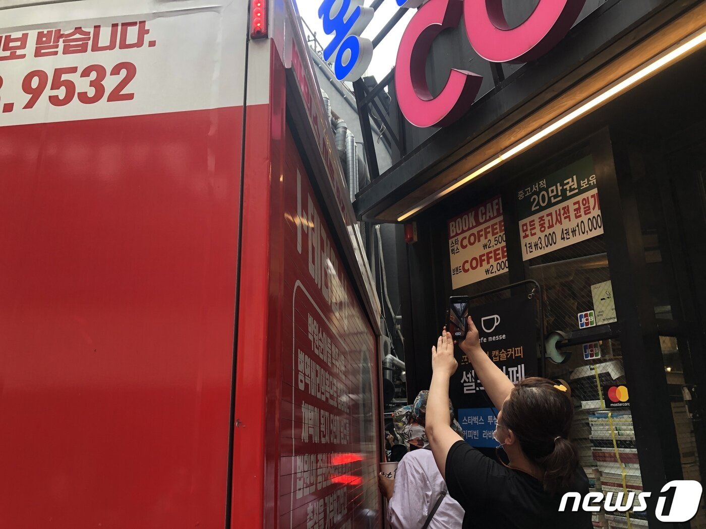 본문 이미지 - 벽화가 그려진 중고서점 간판이 보수 유튜버 차량에 훼손된 모습.ⓒ 뉴스1 금준혁 기자