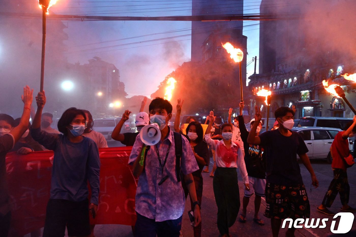 본문 이미지 - 29일(현지시간) 미얀마 양곤서 열린 군사 쿠데타 반대 시위에서 시위대가 횃불을 든 채 세 손가락 경례를 하고 있다. ⓒ AFP=뉴스1 ⓒ News1 서한샘 기자