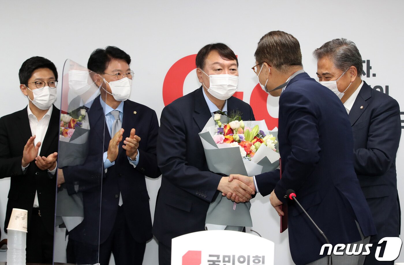 본문 이미지 - 야권 대선주자인 윤석열 전 검찰총장이 30일 오후 서울 여의도 국민의힘 중앙당사에서 대외협력위원장인 권영세 의원에게 입당원서를 제출한 뒤 꽃다발을 받고 있다. 2021.7.30/뉴스1 ⓒ News1 구윤성 기자