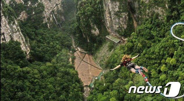 본문 이미지 - 세계에서 제일 높은 다리인 중국 후난성 장가계 유리다리에서 한 사람이 번지 점프를 하고 있다.(뉴미디어 플랫폼 페이스북 갈무리)ⓒ 뉴스1