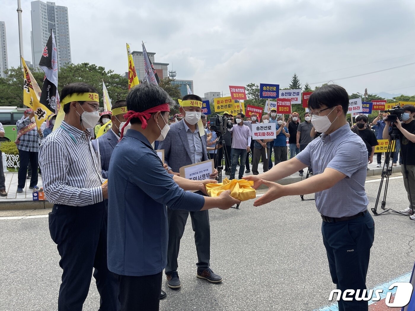 본문 이미지 - 6일 충주시 3개 읍·면 주민이 송전선로 건설 사업에 반대하는 내용의 주민 서명부 5100장을 충주시 관계자에게 전달하고 있다.2021.7.6/ⓒ 뉴스1