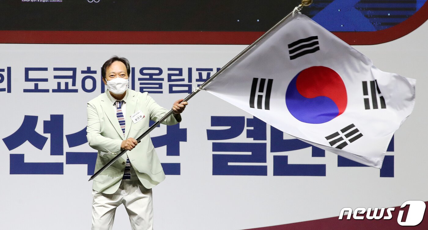 본문 이미지 - 장인화 선수단장이 8일 오후 서울 송파구 올림픽공원 내 올림픽홀에서 열린 '2020 제32회 도쿄하계올림픽대회 대한민국 선수단 결단식'에서 선수단기를 전달받은 후 흔들고 있다. 김진환 기자