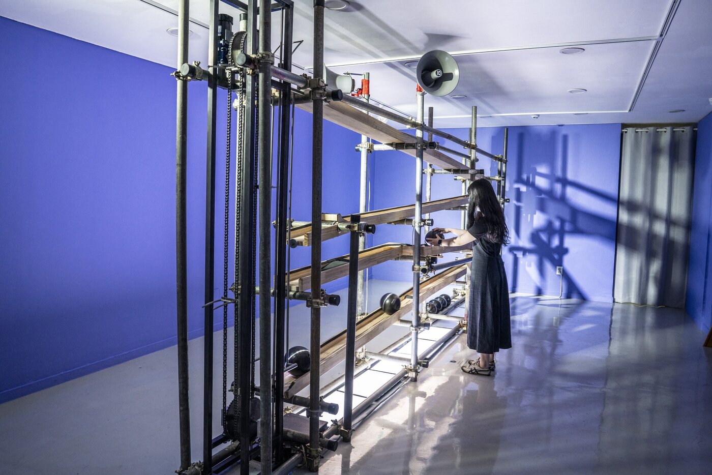 본문 이미지 - 성북예술창작터에서 전형산 작가의 '목소리의 극장'전이 열린다. 직원이 작품 '균형의 함정#1;높은-소리, 낮은-소리' 앞에서 작동법을 선보이고 있다. 서울관광재단 제공