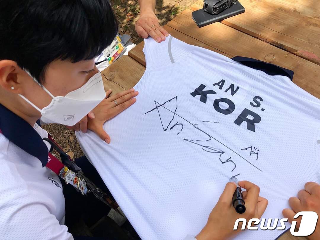 본문 이미지 - 2020 도쿄올림픽 양궁 경기에서 안산&#40;광주여대&#41;과 김제덕&#40;경북일고&#41;이 연출한 &#39;로빈후드&#39; 화살이 국제올림픽위원회&#40;IOC&#41; 올림픽 박물관에 전시된다. 함께 기증할 유니폼에 사인하는 안산. &#40;대한양궁협회 제공&#41; 2021.8.1/뉴스1 ⓒ News1 이성철 기자