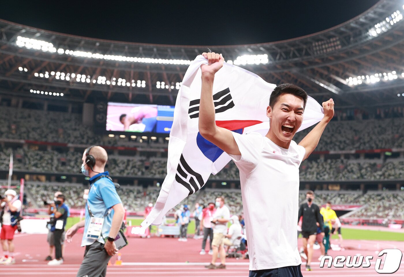 본문 이미지 - 2.35m를 넘으며 한국 육상 높이뛰기 신기록을 세운 우상혁 선수가 올림픽스타디움에서 태극기를 흔들고 있다. 2021.8.1/뉴스1 ⓒ News1 올림픽사진취재단