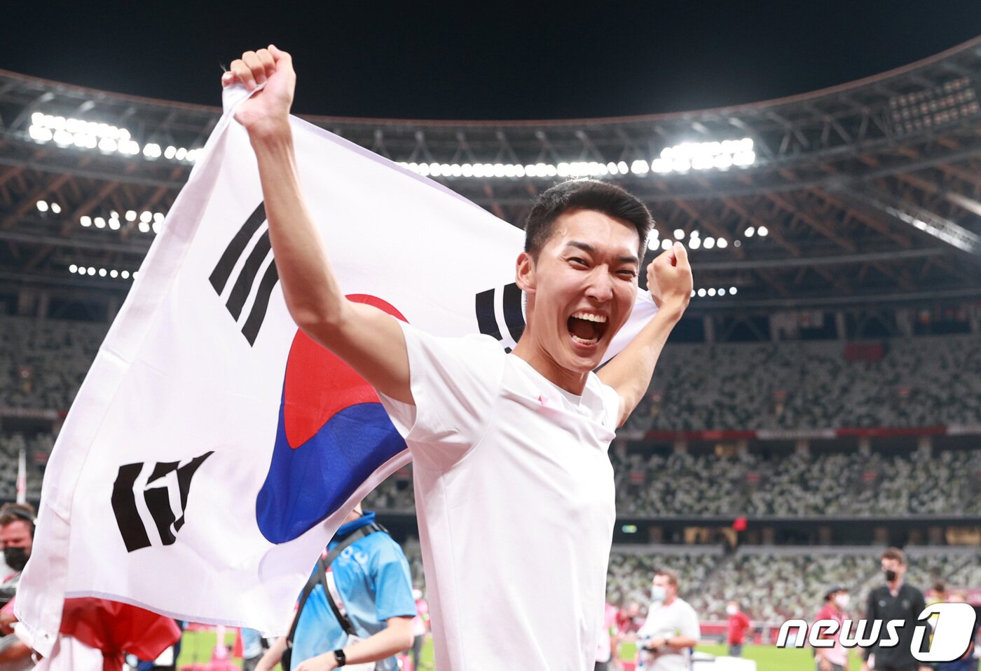 본문 이미지 - 2.35m를 넘으며 한국 육상 높이뛰기 신기록을 세운 우상혁이 1일 오후 도쿄 올림픽스타디움에서 열린 '2020 도쿄올림픽' 남자 높이뛰기 결승전을 4위로 마치고 태극기를 흔들고 있다. 2021.8.1/뉴스1 ⓒ News1 올림픽사진취재단