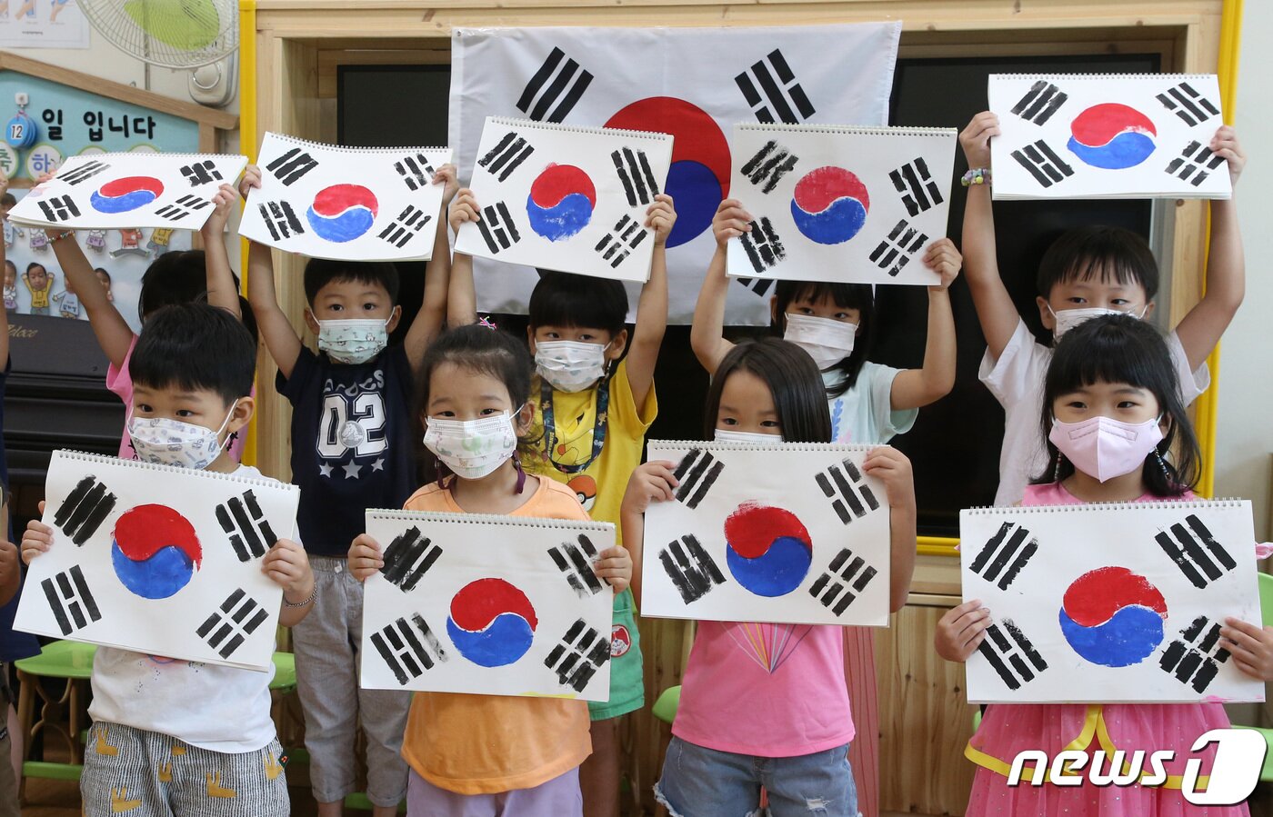 본문 이미지 - 광복절을 앞두고 12일 대전 서구청 어린이집 원생들이 스텐실 기법으로 직접 만든 태극기를 들어 보이고 있다. ⓒ News1 김기태 기자