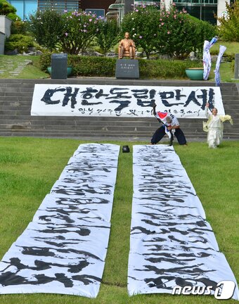 본문 이미지 - 광복 76주년을 앞둔 12일 서예가 김동욱 씨와 한국 고살풀이춤 보존회 이희숙 회장이 경북 포항시 북구 기계면 문성리 새마을 운동 발상지 기념관 앞에서 '광복을 축하하고 독도를 지키다 순직한 독도의용수비대원의 넋을 기리는 퍼포먼스를 펼치고 있다. 2021.8.12/뉴스1 ⓒ News1 최창호 기자