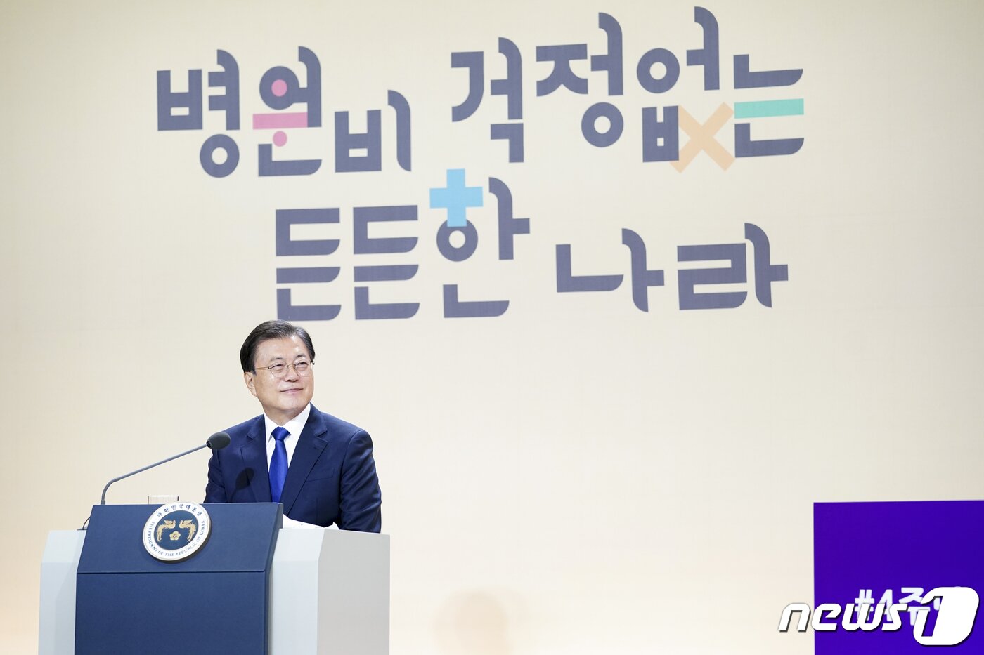 본문 이미지 - 문재인 대통령이 12일 청와대에서 열린 건강보험 보장성 강화대책 4주년 성과 보고대회에서 화상을 통해 보장성 강화 수혜 사례 발표를 듣고 있다.2021.8.12/뉴스1 ⓒ News1 이광호 기자