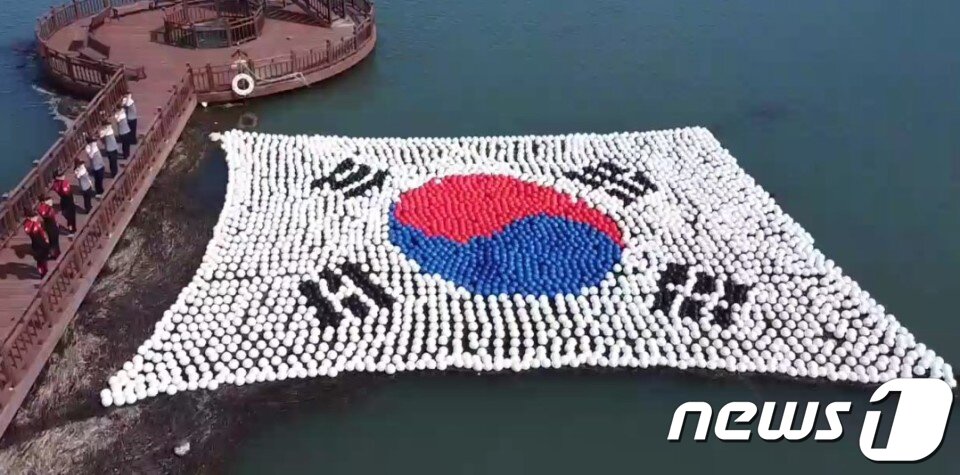 본문 이미지 - 광복절을 앞둔 13일 전남 완도군 소안도 해상에서 해양경찰관들이 태극기 모양의 부표를 향해 경례하고 있다. 완도해경 노화파출소 경찰관들은 이날 소안도를 찾아 수중정화 활동을 펼치며 해상주권 수호의지를 다졌다. ⓒ완도해경 제공
