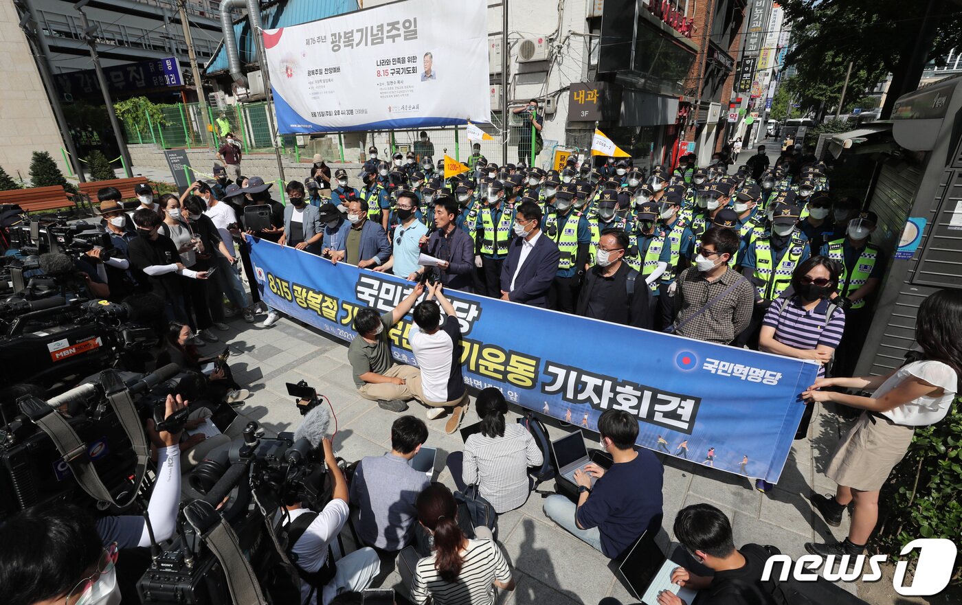 본문 이미지 - 15일 서울 종로구 새문안교회 앞에서 경찰이 기자회견을 위해 동화면세점 쪽으로 이동하려는 국민혁명당 관계자들을 막아서자 그 자리에서 기자회견을 열고 있다. 2021.8.15/뉴스1 ⓒ News1 이성철 기자