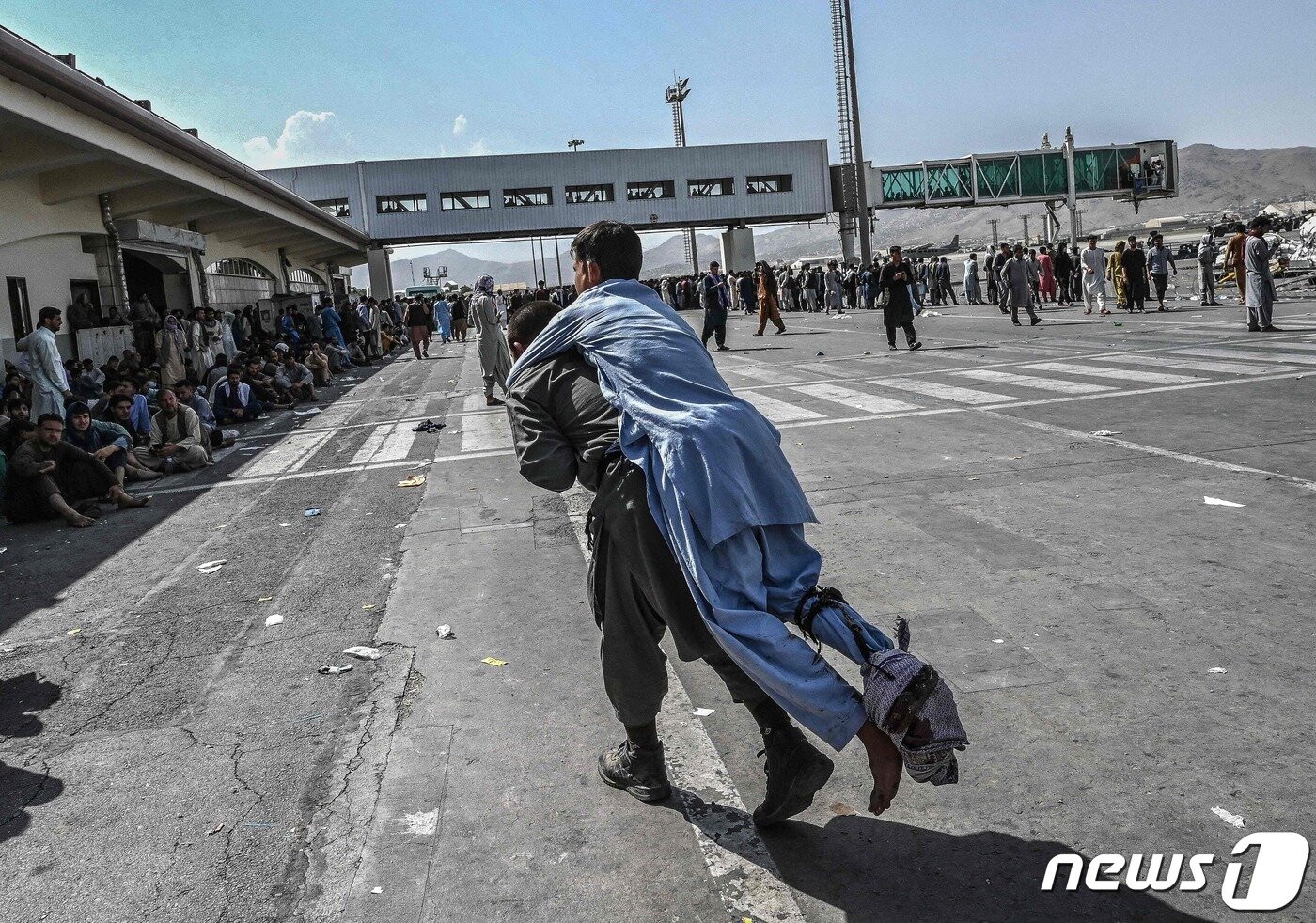본문 이미지 - 16일(현지시간) 아프가니스탄 정권 붕괴 후 카불 공항에서 자원 봉사자가 부상 당한 시민을 옮기고 있다. ⓒ AFP=뉴스1 ⓒ News1 우동명 기자