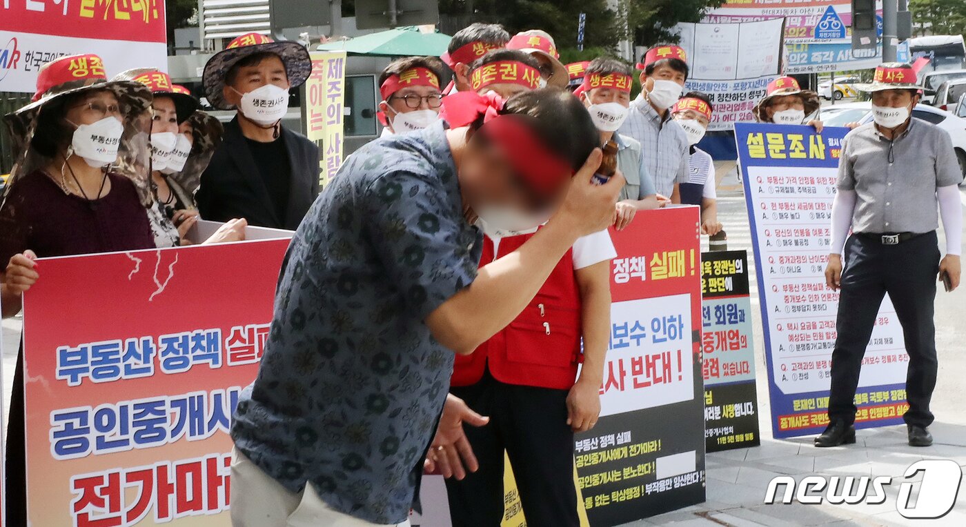 본문 이미지 - 17일 정부세종청사 국토교통부 앞에서 한국공인중개사협회 회원들이 정부의 중개수수료 인하 추진 중단 촉구 집회를 갖던 중 한 참가자가 국토부에 항의하며 머리에 유리병을 부딪히고 있다. ⓒ News1 장수영 기자