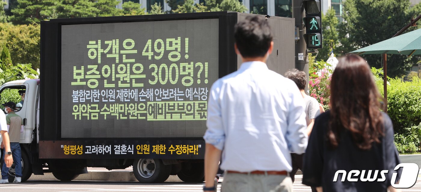 본문 이미지 - 현행 사회적 거리두기 단계에 따른 예식장 인원 제한과 실효성 없는 분쟁 해결 대책에 결국 불만이 터진 예비부부들이 지난 19일 서울 중구 서울시청 앞에서 트럭시위를 하고 있다.  ⓒ News1 박지혜 기자