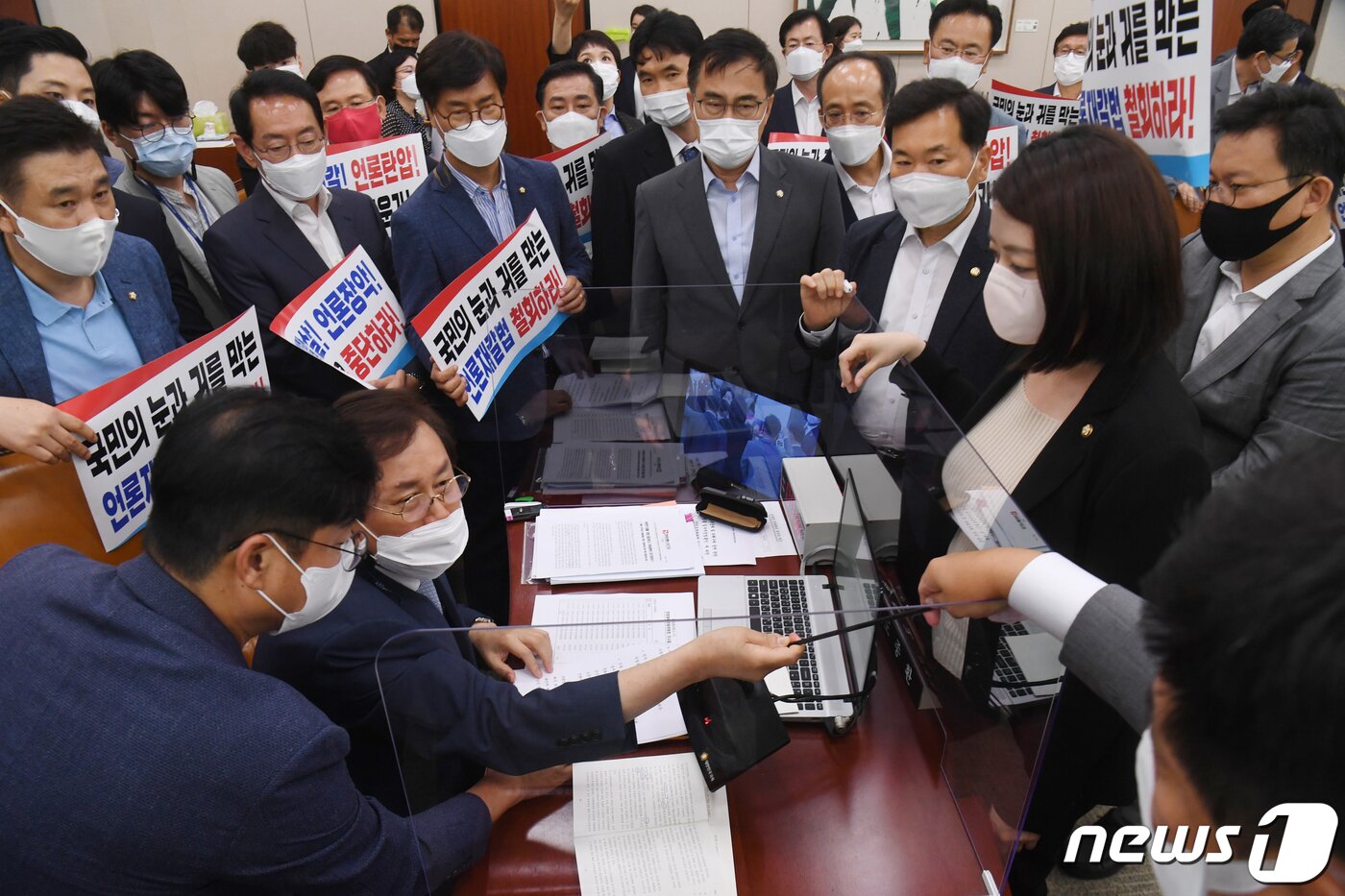 본문 이미지 - 19일 오후 서울 여의도 국회 문화체육관광위원회 전체회의에서 국민의힘 의원들이 언론중재법 개정안 통과시키려는 도종환 위원장의 회의 진행를 막아서고 있다. 더불어민주당은 이날 고의·중과실로 허위·조작 보도를 할 경우 최대 5배의 징벌적 손해배상을 하도록 하는 언론중재법 개정안을 국민의힘의 반발 속에 단독 처리했다. ⓒ News1 오대일 기자