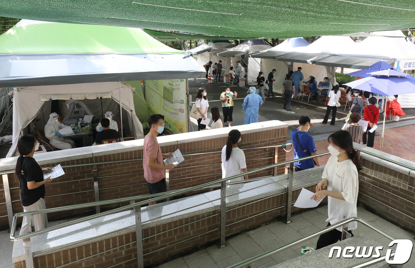본문 이미지 - 20일 오전 대구 달서구보건소 선별진료소에서 시민들이 줄지어 신종 코로나바이러스 감염증(코로나19) 진단검사를 기다리고 있다. ⓒ News1 공정식 기자