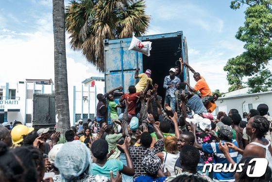 20일(현지시간) 아이티 남서부 항구도시 레카예에서 한 남성이 지진 피해자들에게 구호 물품을 전달하고 있다. 2021.08.20 © AFP=뉴스1