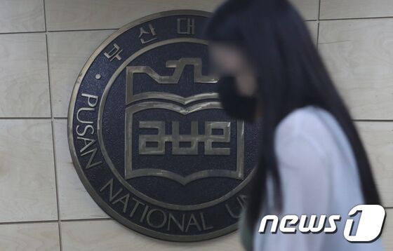 24일 오후 부산 금정구 부산대학교 로고 앞으로 학생이 지나가고 있다. 이날 부산대는 조민 씨의 의전원 입학을 취소하기로 결정했다고 밝혔다. © News1 여주연 기자